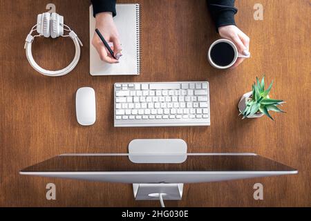 Top view, woman working at the computer, wooden table. Stock Photo