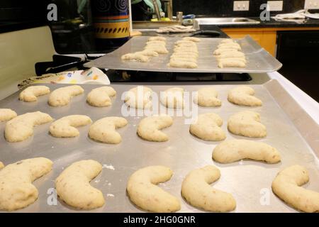Trays of Mexican wedding cookies cooling on a baking tray on top of a stove in a household kitchen prior to dusting with powdered sugar. Stock Photo
