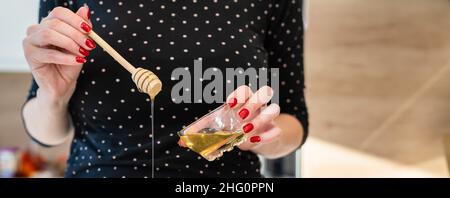 Close up on hand of unknown caucasian woman holding and pouring honey copy space Stock Photo