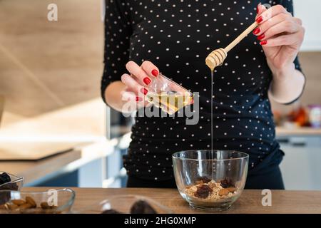 Close up on hand of unknown caucasian woman holding and pouring honey copy space Stock Photo