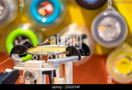 manual stringing of a badminton racket in service Stock Photo