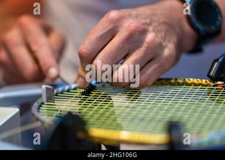 manual stringing of a badminton racket in service Stock Photo