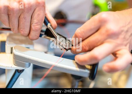 manual stringing of a badminton racket in service Stock Photo