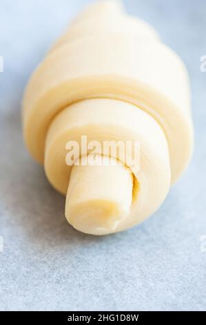 Semifinished or unbaked croissant on a baking sheet. Puff pastry baking. Overhead view. Stock Photo