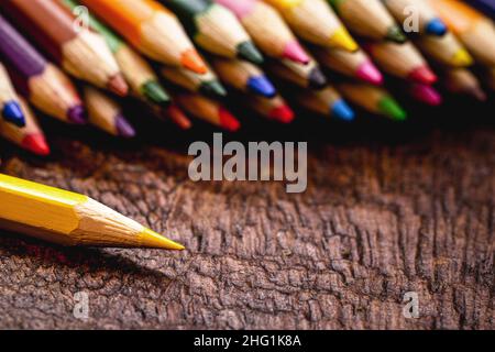macro photograph of colored school pencils, under rustic wood table, with copyspace for text Stock Photo