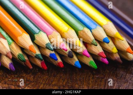 macro photograph of colored school pencils, under rustic wood table, Stock Photo