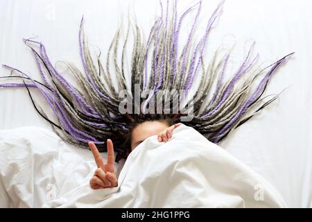 Young women with dreadlocks is covering by blanket Stock Photo