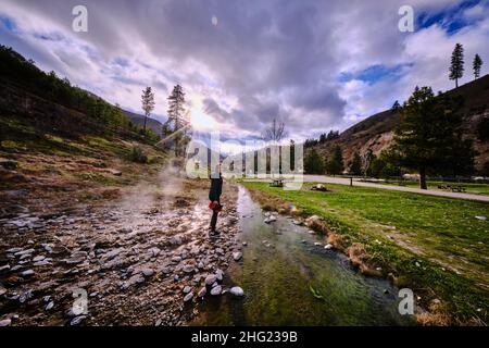 A young woman following the water at Kirkham hot springs. Stock Photo