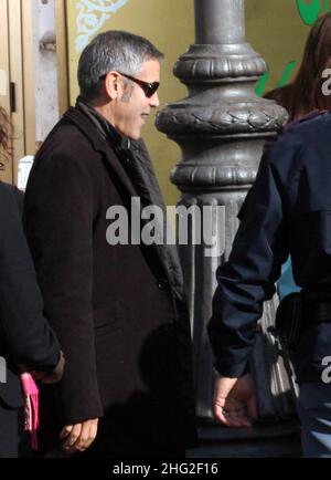 George Clooney on the set of his new movie (working title 'The American') in Rome, Italy. Besides the normal bodyguards there were also Italian police to take care of him. He left the set to have a dinner in a restaurant. Stock Photo