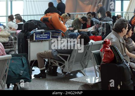 European airports are still at a stand still caused by Icelandic volcano Eyjafjollajokull. Passengers waiting in Rome Fiumicino airport, Rome Stock Photo