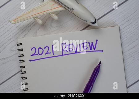 2021 Review write on a book isolated on Wooden Table. Stock Photo