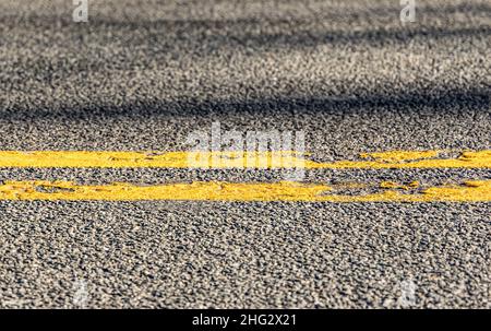 detail of a double yellow line on an asphalt road Stock Photo