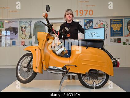 10 January 2022, Brandenburg, Eisenhüttenstadt: Sabrina Kotzian, an employee of the Museum Utopia and Everyday Life, stands next to a Schwalbe-type moped in the permanent exhibition with a laptop containing the homepage of the digital participation platform. Last year, the Museum Utopia and Everyday Life in Eisenhüttenstadt designed a new digital participation platform for sharing memories and object stories. It provides an insight into the collections of everyday culture and art from the GDR. The platform invites people to share experiences, memories and stories that visitors associate with t