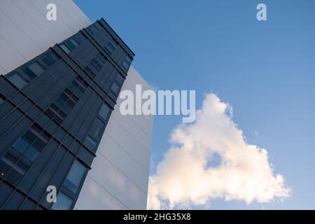 Looking up at residential building and rare cloiud in a form of triangle with blue sky and copy space Stock Photo