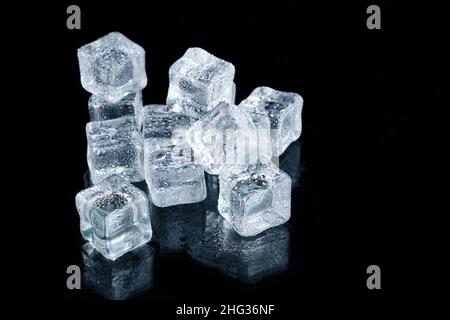 Ice cubes are covered with water droplets on a black background Stock Photo
