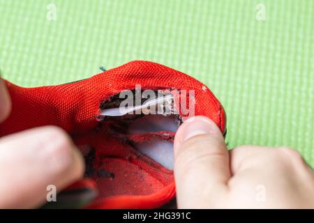 Repair of a torn heel in low-quality shoes Stock Photo