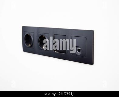Broken black electrical switch socket-compatible built into white wall Stock Photo