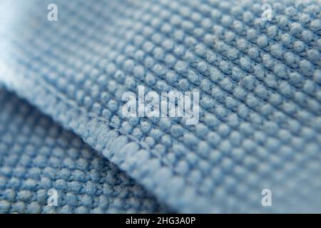 Blue cloth for cleaning the screen of the phone, tablet, TV, glasses. Microfiber structure. Selective focus. Macro filming. Stock Photo