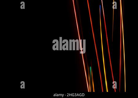 Bright multicolored diagonal lines rays on black. Abstract dark background banner. Place for text or message Stock Photo