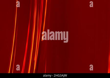 Bright red lines rays on a burgundy background. Abstract backdrop with soft blur. Energy and speed. Stock Photo