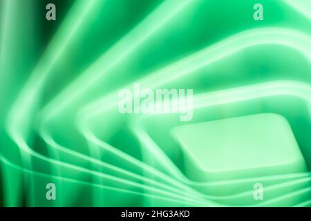 Abstract green glow of a bright LED lamp on the ceiling in the room in the form of waves, squares and rhombuses. Stock Photo