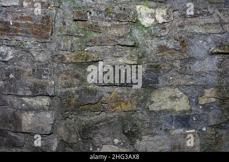 Old castle wall, cracked stonework. Background from stones and cement mortar. Stock Photo