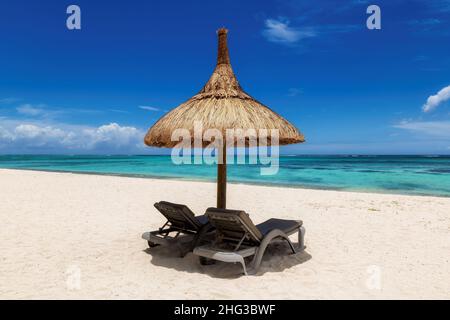Straw umbrella in Sunny tropical beach Stock Photo