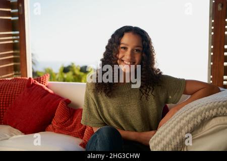 African American female smiling while sitting on sofa  Stock Photo