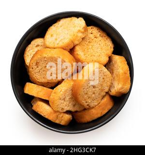 Olive and tomato bruschetta chips in a black ceramic bowl isolated on white. Top view. Stock Photo