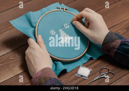Craftsperson fixing thread on canvas in indoors. Stock Photo
