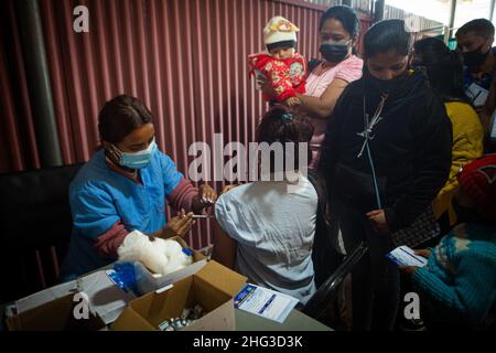 Kathmandu, Bagmati, Nepal. 18th Jan, 2022. A paramedic inoculates a person with anti-COVID vaccine at Teku Hospital in Nepali capital Kathmandu. Serpetine lines stretching far and wide as government makes vaccination card mandatory to take public services or to be at public areas starting from 21 January, 2022. (Credit Image: © Amit Machamasi/ZUMA Press Wire) Stock Photo