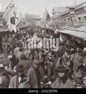 Vintage photo of the 19th century Japan. Crowds in the street leading to Asakusa Park, the famous recreation quarter of Tokyo, Japan. 1905 Stock Photo