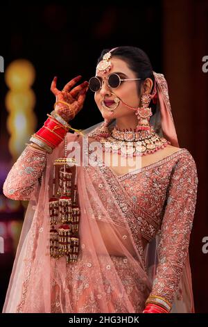 Beautiful Indian bride wearing sunglass during wedding ceremony Stock Photo