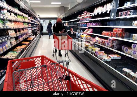 A shopper pushes her shopping cart past the clearance aisle at the