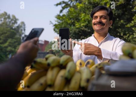 Man paying seller through online using Smartphone Stock Photo