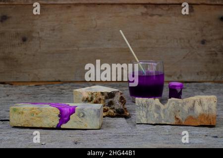 Timber burl woodchips color bottle and resin epoxy for casting wood on old wooden table background Stock Photo