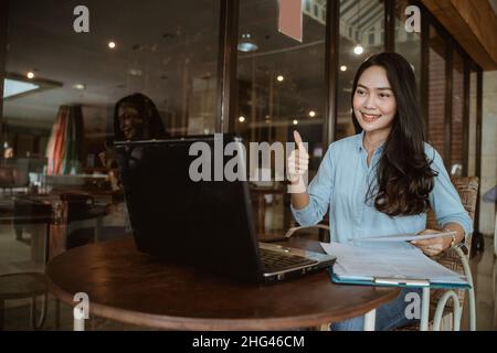 Freelancer woman working using laptop with thumbs up hand gesture Stock Photo