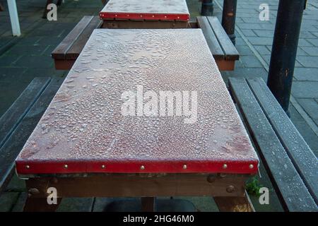 Windsor, Berkshire, UK. 18th January, 2022. Frozen table tops outside a restaurant. It was a cold morning today in Windsor as temperatures were -2 degrees. There was a heavy overnight frost and fog. Credit: Maureen McLean/Alamy Live News Stock Photo