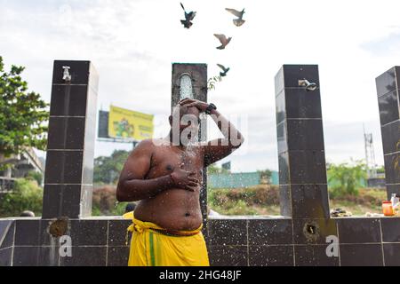 Kuala Lumpur, Malaysia. 18th Jan, 2022. A Hindu devotee cleans himself to celebrate the Thaipusam festival with at Batu Caves on the outskirts of Kuala Lumpur, Malaysia, Jan. 18, 2022. Credit: Chong Voon Chung/Xinhua/Alamy Live News Stock Photo