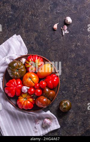 The harvest of assorted tomatoes. Colorful organic tomatoes on a large dish. Tomatoes different varieties. Top view Stock Photo