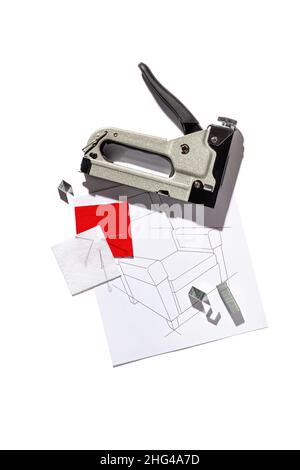 Silver furniture stapler gun with staples and the drawing of the armchair isolated on white background. Manual industrial tool Stock Photo