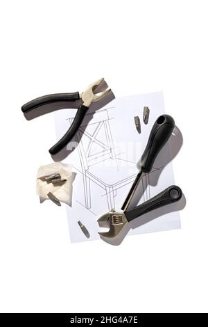 Furniture hand industrial tools and chair assembly drawing isolated on white background, close up, flat lay Stock Photo
