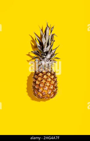 Fresh pineapple with shadow on table. Isolated on yellow background, close-up, flat lay Stock Photo