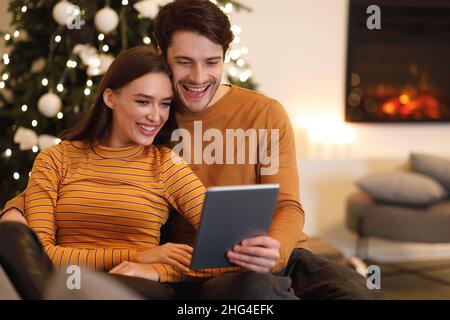 Smiling young couple using digital tablet at home Stock Photo