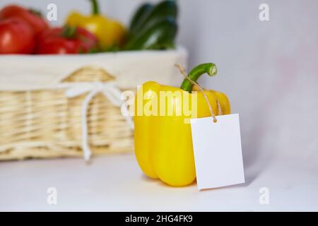 Mock up label on bell pepper. Sticker product for text or price. Basket of vegetables on background. Organic farm products from local market Stock Photo