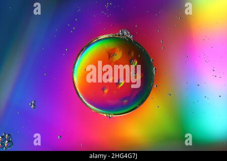 close-up of an oil droplet on an illuminated water surface, abstract background Stock Photo