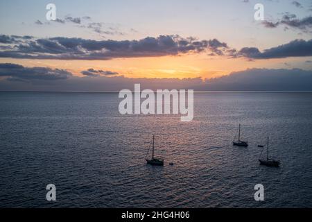 Boats moored outside the harbour at sunset in Playa San Juan, Tenerife, Canary Islands, Spain Stock Photo