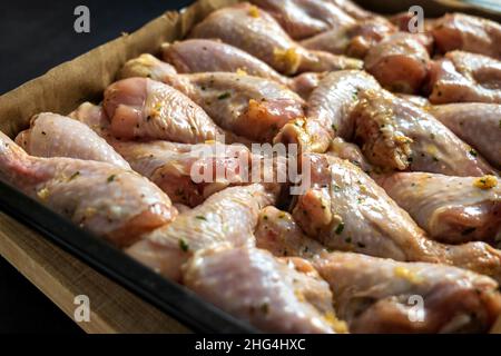raw chicken drumsticks on baking tray prepared for oven Stock Photo