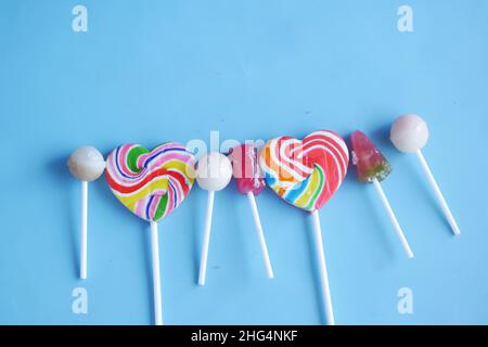 rainbow heart shape lollipop on blue background  Stock Photo