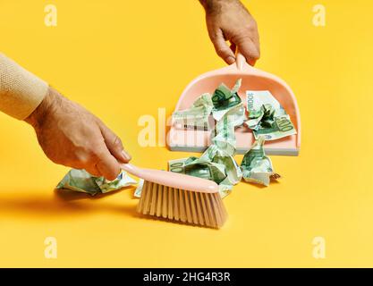 Creative layout with male hand sweeping money dollar bills on yellow background. Finance, corruption, criminal activity concept Stock Photo